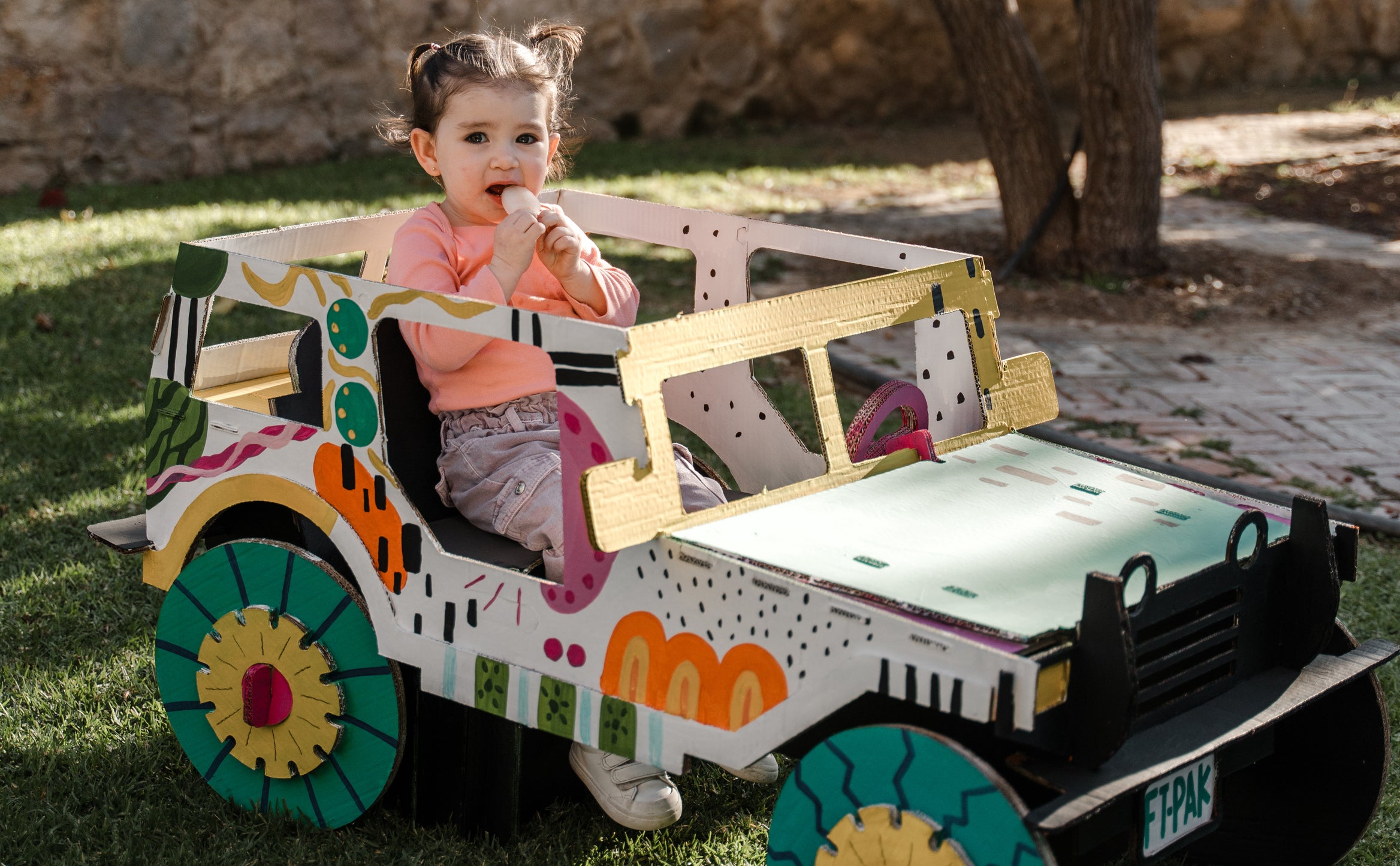 Bebé comiendo paleta sobre un carrito de cartón Krtoon World.